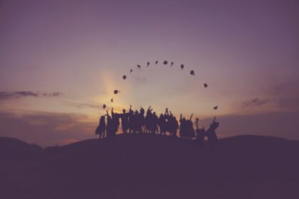 silhouette of people standing on hill